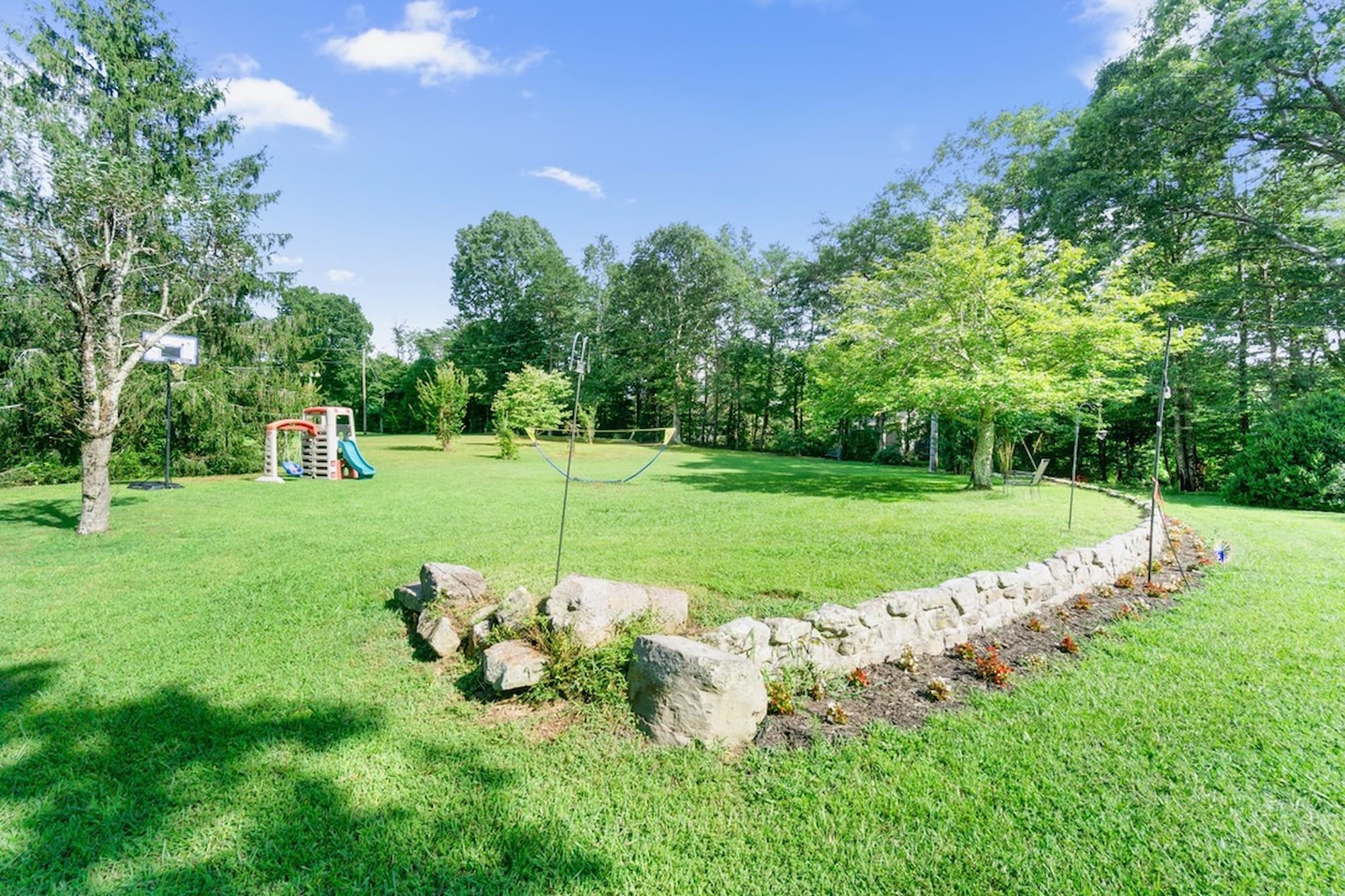 Level play yard with basketball goal, badminton net, and toddler playset