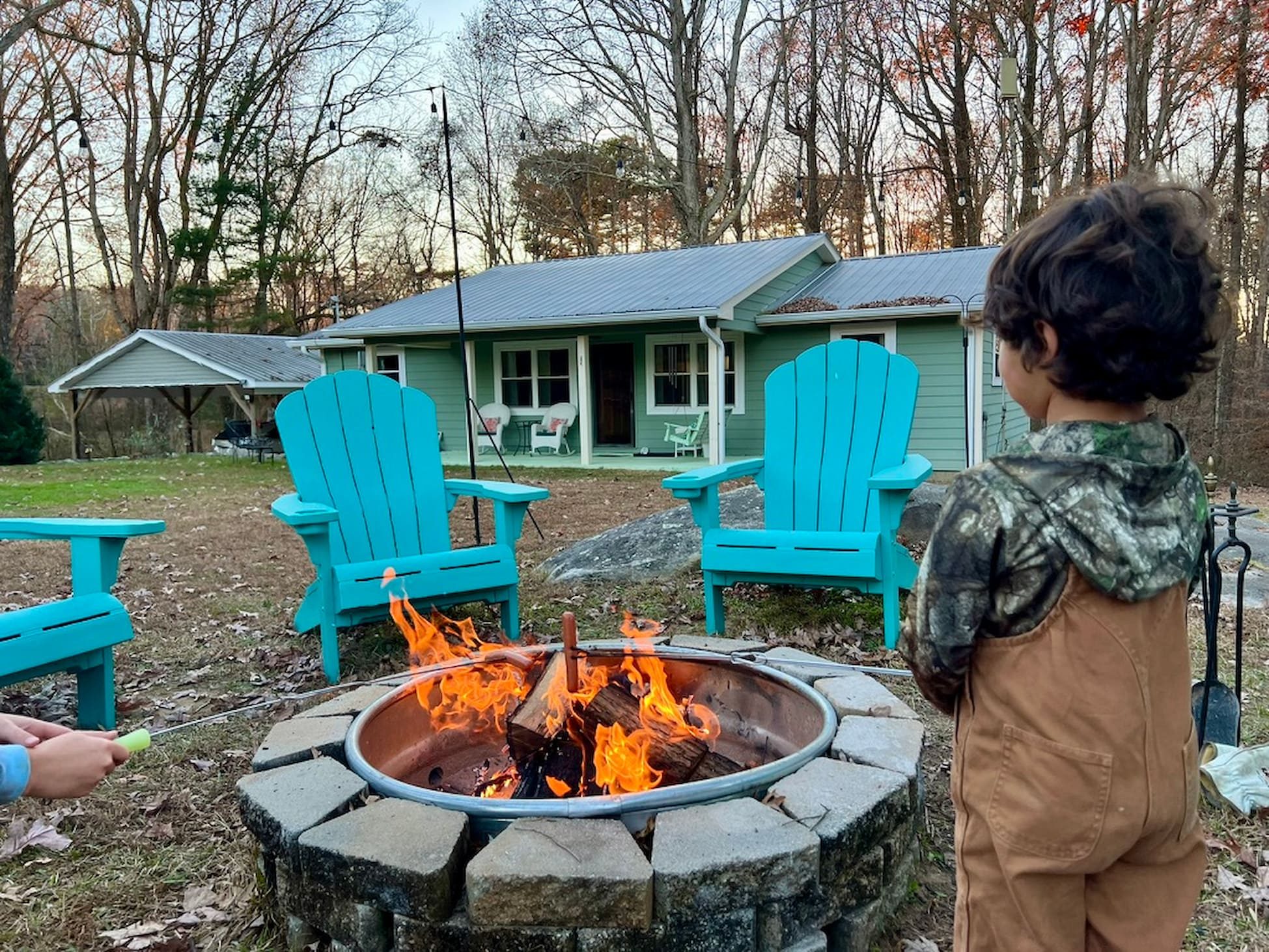 Evening s'mores at the fire pit as the sun sets behind the house