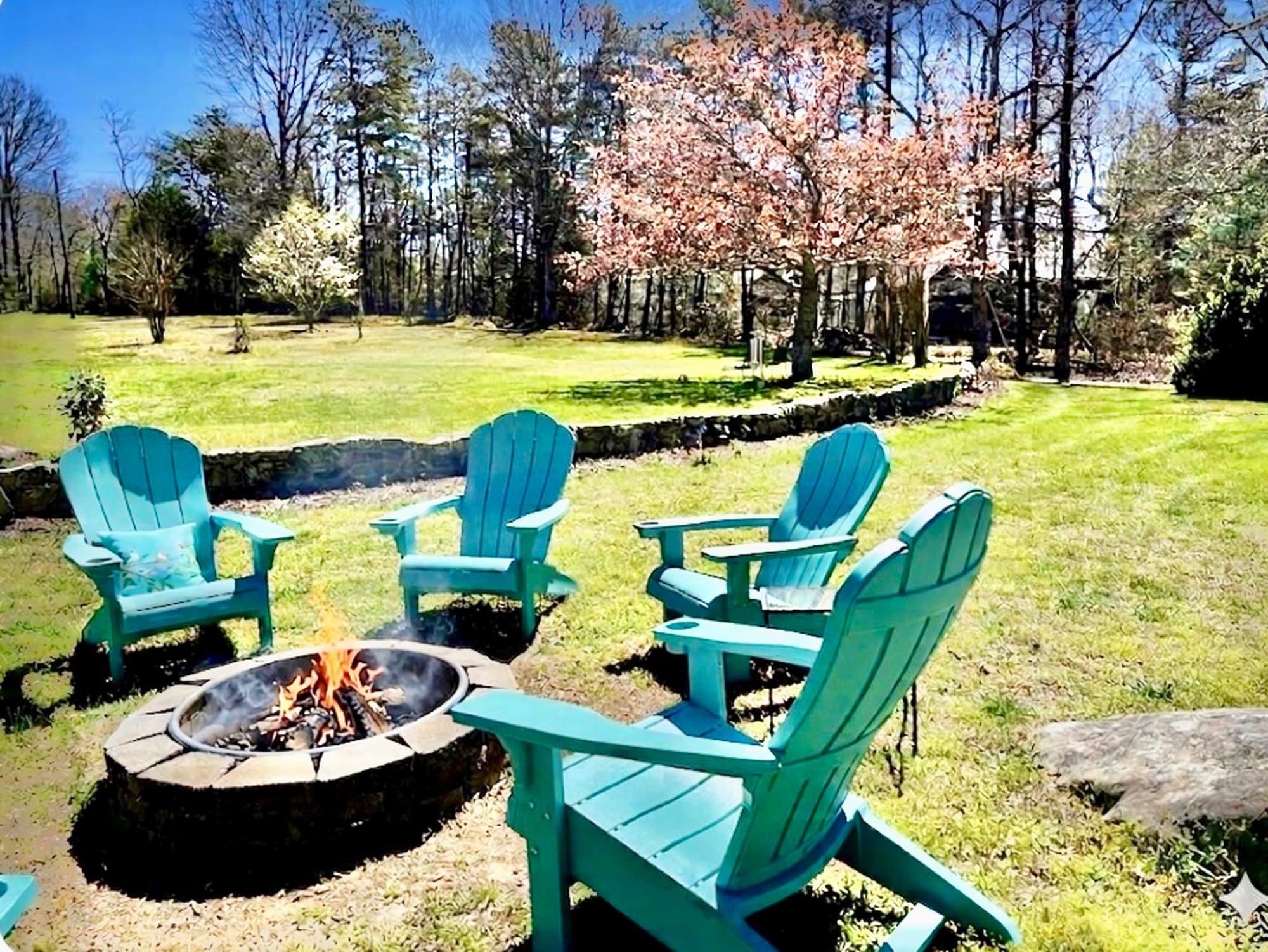 Fire crackling in the stone fire pit surrounded by Adirondack chairs