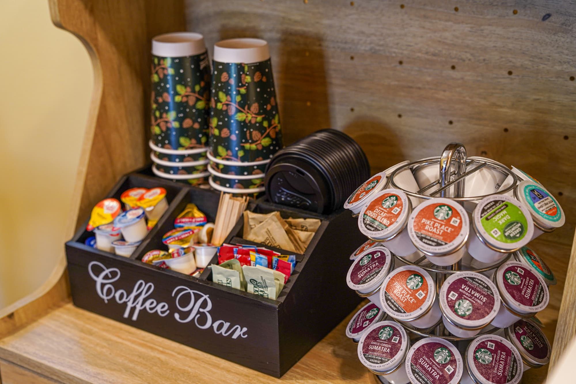 Stocked coffee bar with Starbucks K-cups, creamers, and to-go cups
